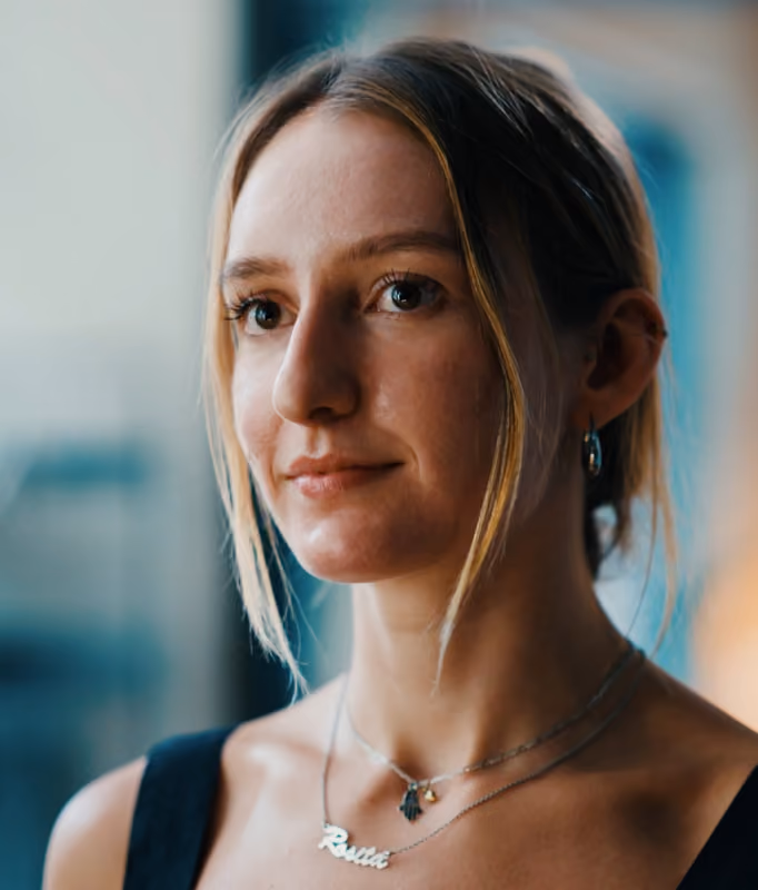 Portret van een jonge vrouw met blonde haar en een ketting met de naam Rosita.