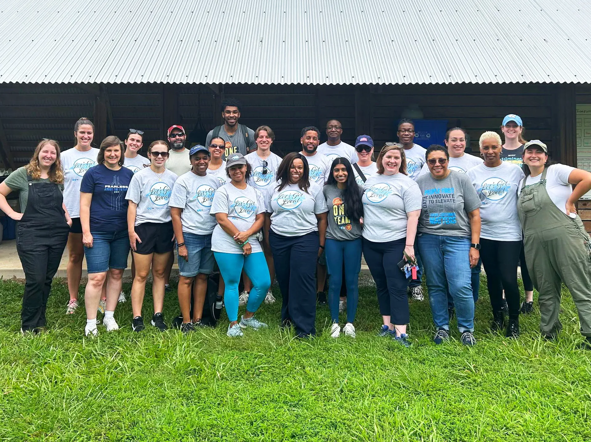 A group of volunteers gathered in front of the barn at Benevolence Farm