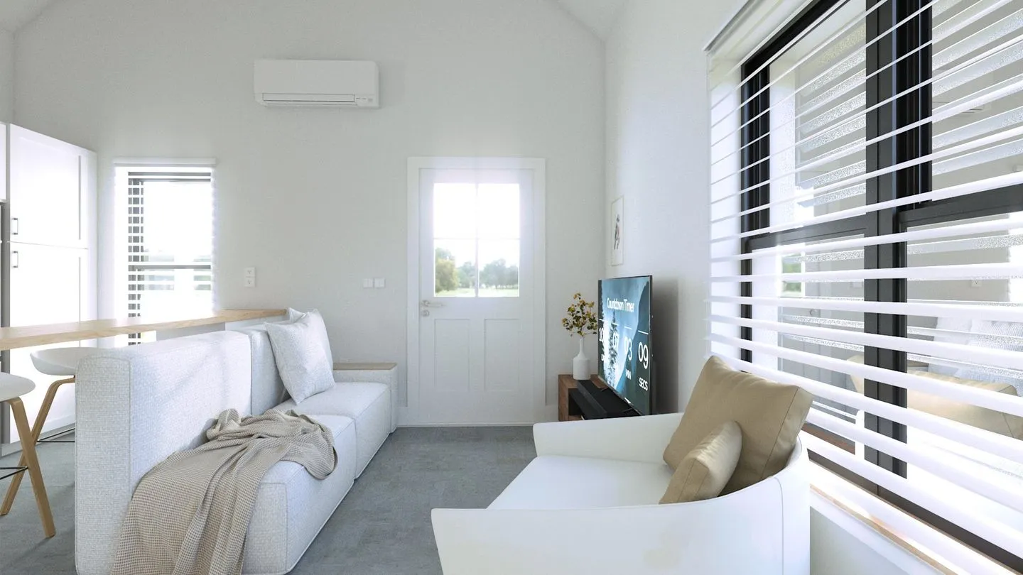Interior of a finished tiny home, looking from the kitchen through the living room to the front door