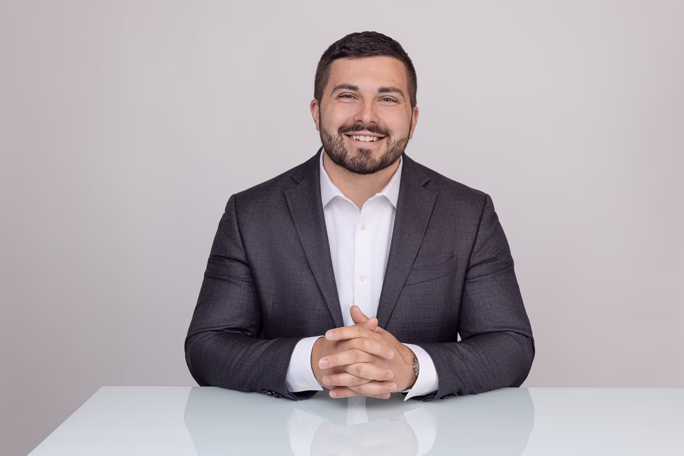 Smiling headshot of attorney Jonathan C. Veres with hands clasped