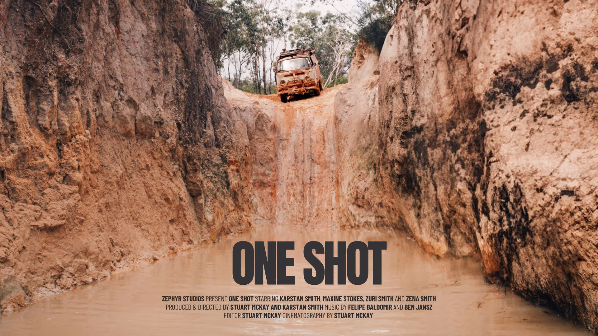 Rusty van perched at the edge of a steep dirt cliff above a water-filled pit titled 'ONE SHOT' with film credits below.