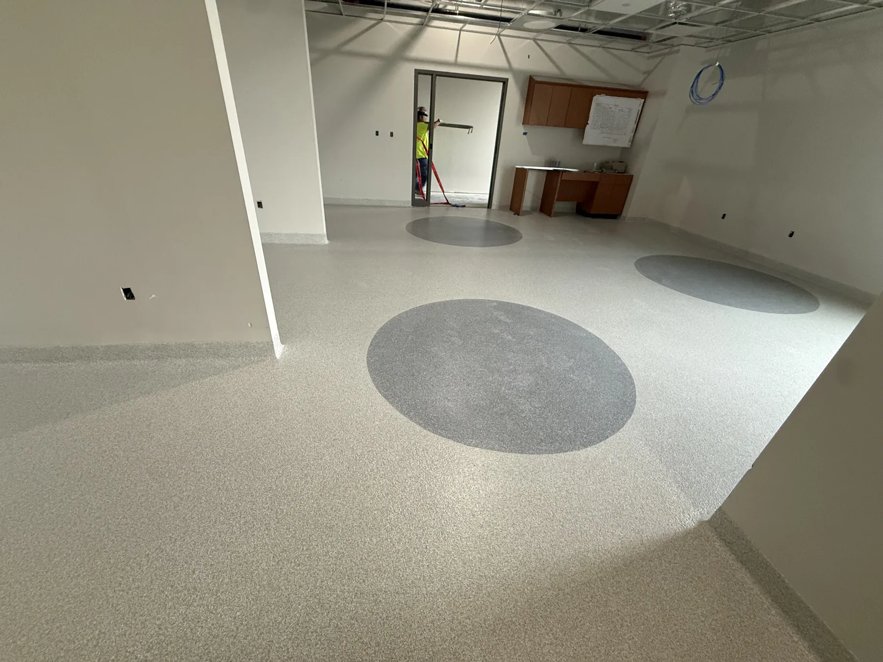 Rehab and physical therapy room in a St. Joseph, MO hospital with decorative flake epoxy floor, gray inset circles and cove base