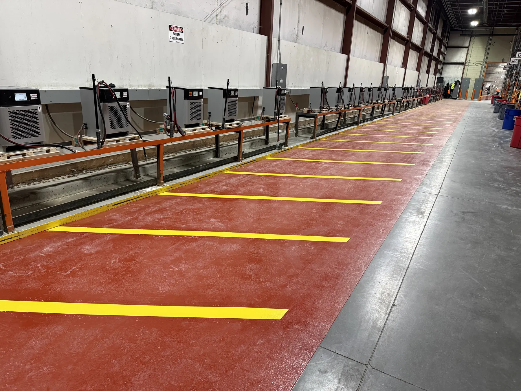 Forklift charging bay with red epoxy floor and yellow line striping at Performance Food Service in Springfield, MO