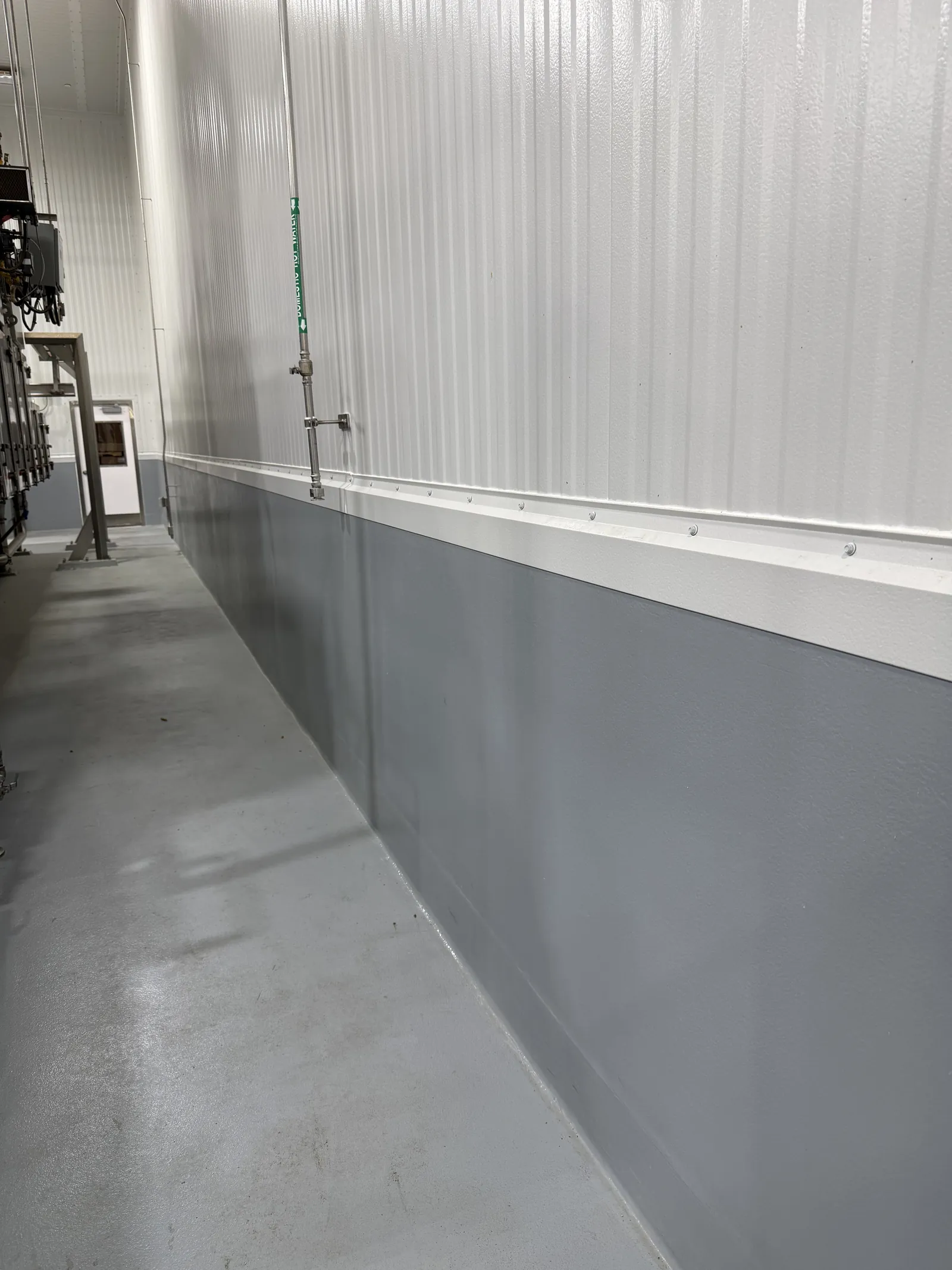 Gray epoxy wall coating with cove transition in a wash-down room