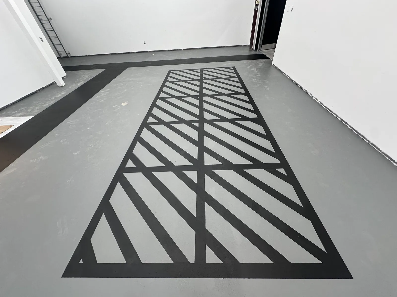 Black hatch line striping on a gray epoxy floor