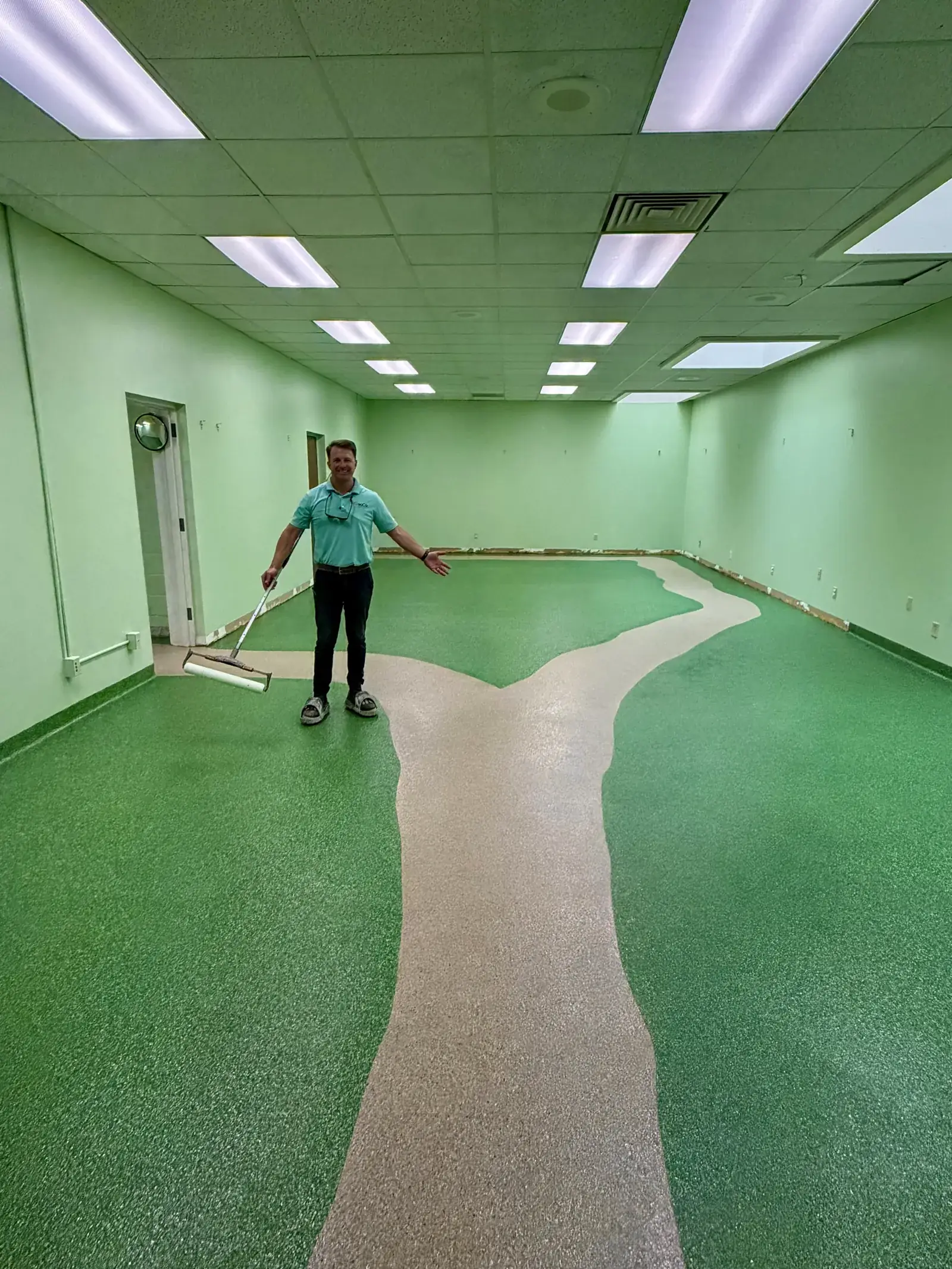 GroCo co-owner Michael Groff rolling the topcoat on a green flake epoxy library floor