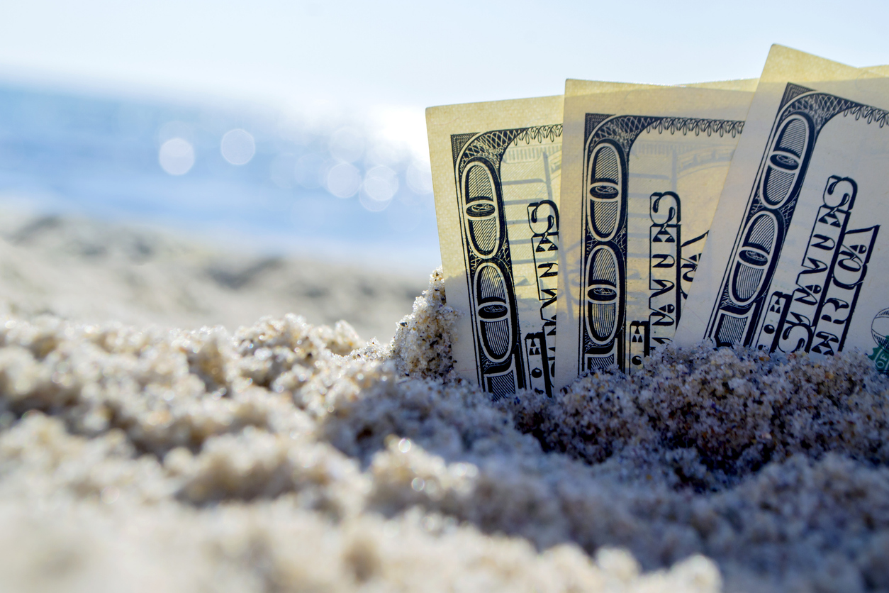 Cash on the sand, representing the financial cost of divorce