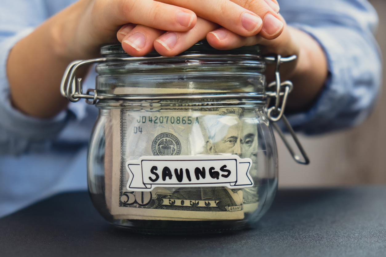 Saving money in a jar, representing ways to have a low-cost divorce