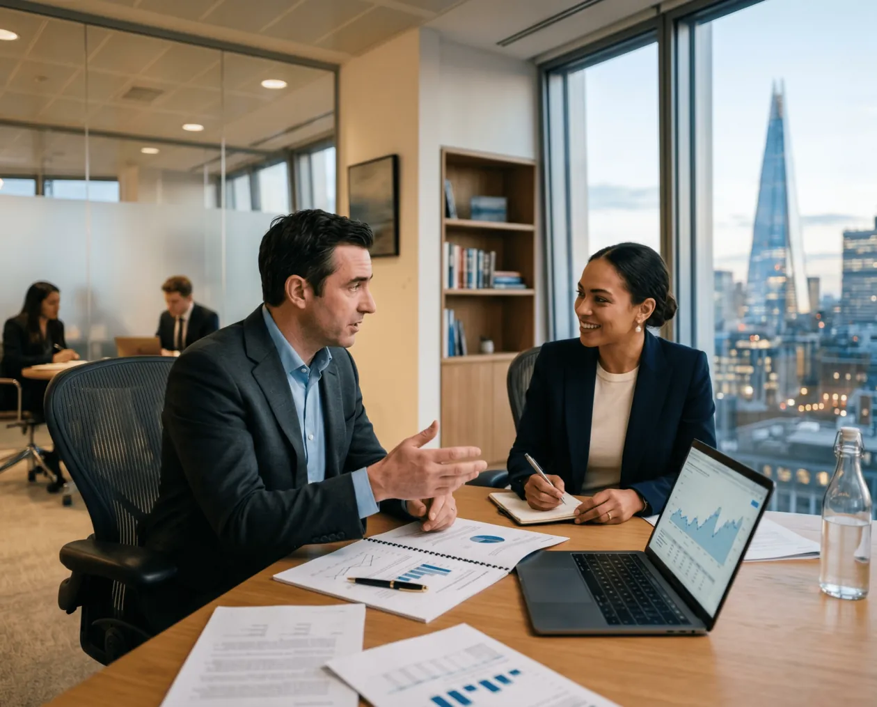 Advisor and client reviewing growth charts at a desk
