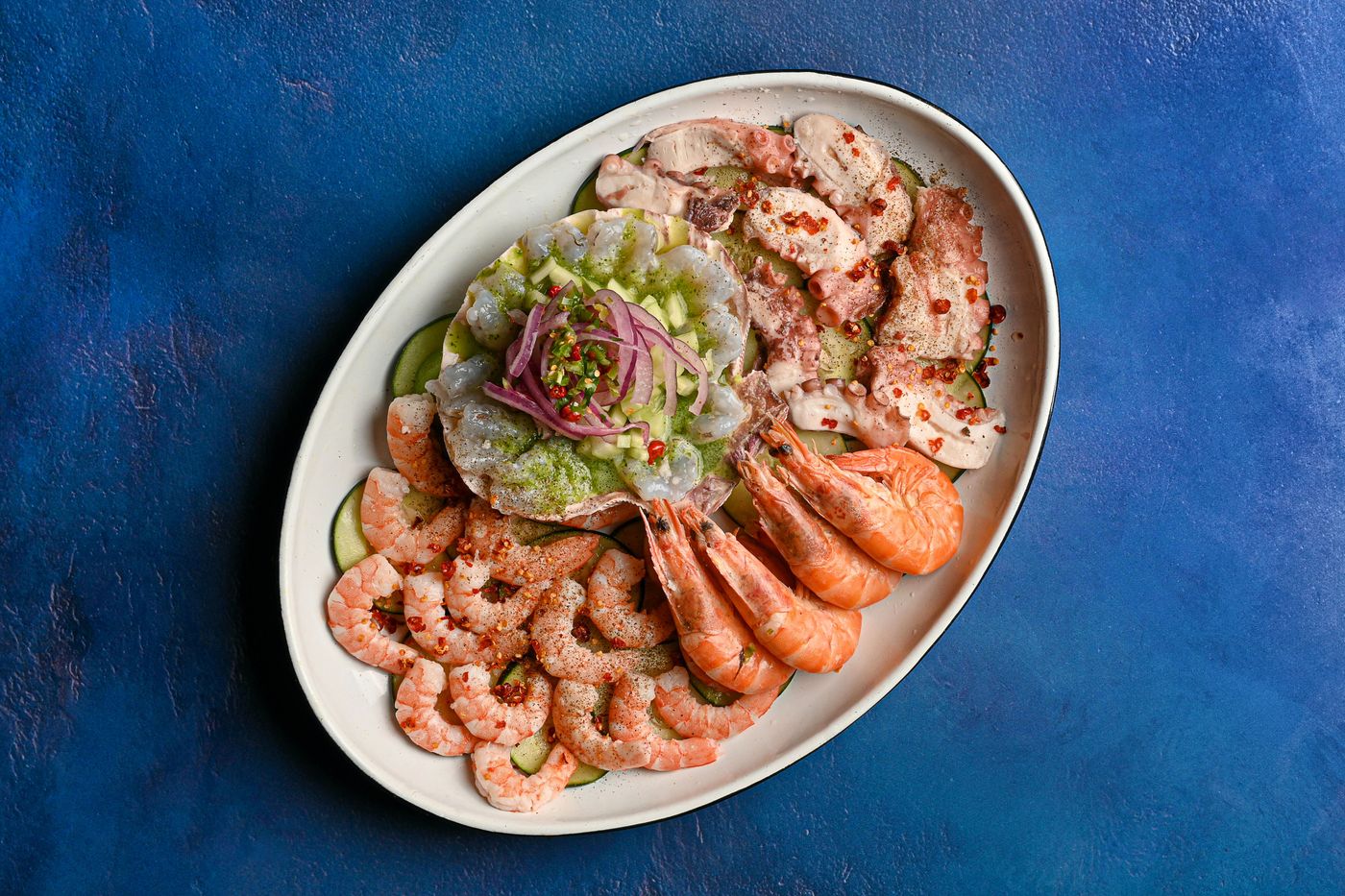 Chilled shrimp piled on a platter with avocado and lime