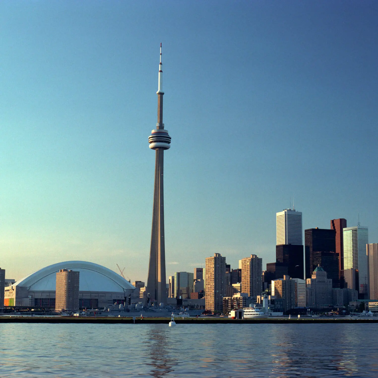 Toronto skyline with CN Tower and downtown buildings reflected in waterfront.