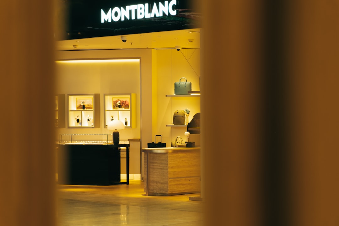 Interior view of a premium luxury goods retail store displaying high-end accessories and merchandise in glass showcases with elegant lighting