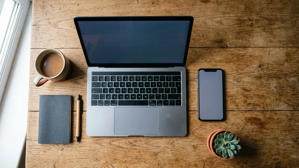 Smartphone and laptop side by side on a wooden desk during a website page speed test