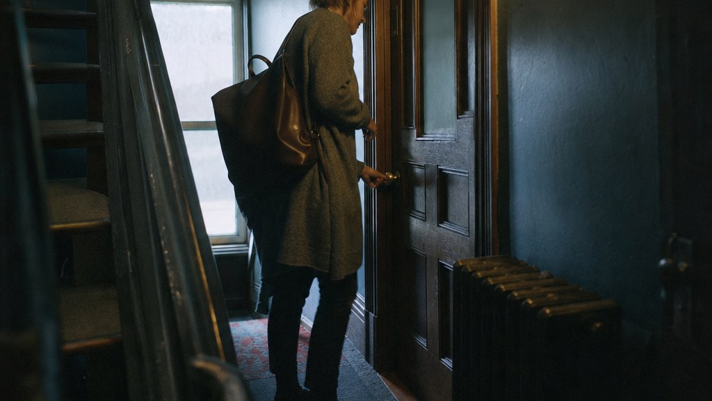 Therapist unlocking a small second-floor counselling office in winter light
