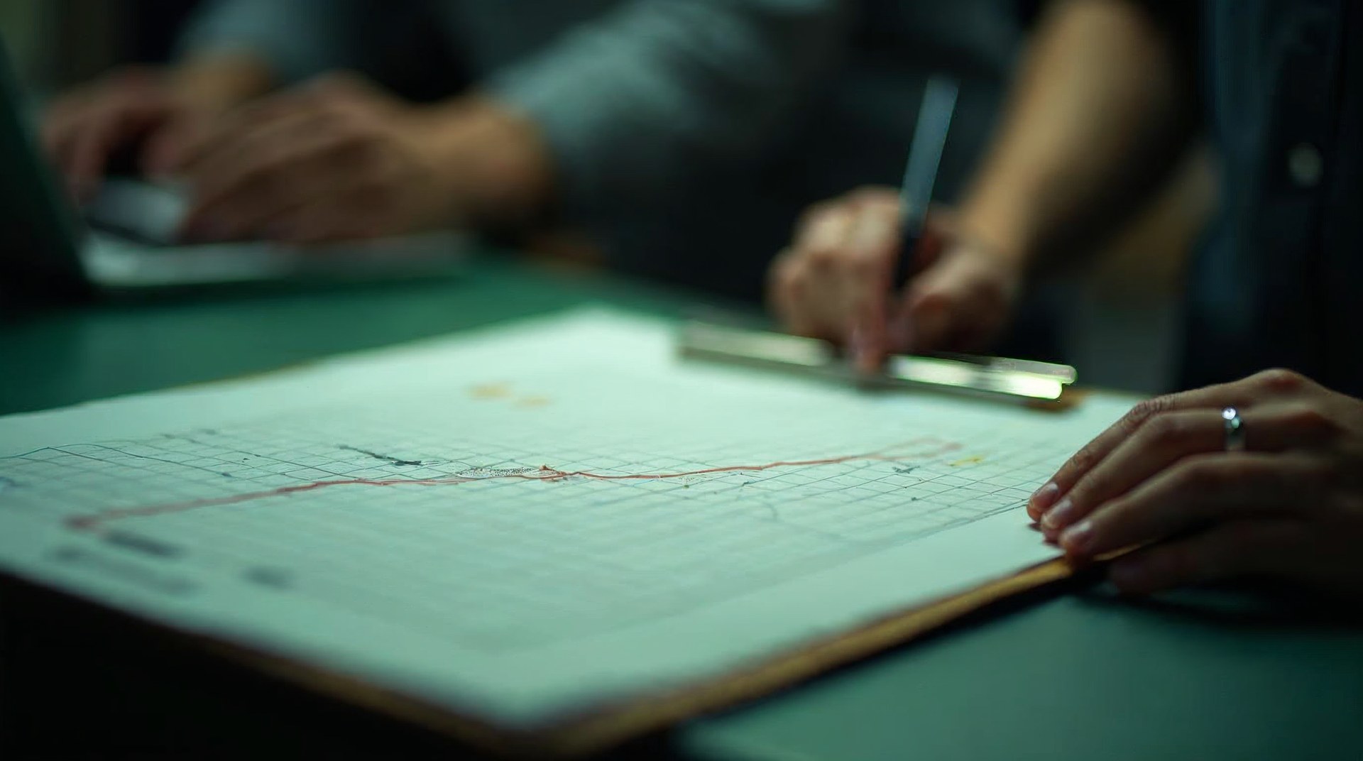 Hand-drawn repeat purchase curve on grid paper clipped to a clipboard on a packing bench