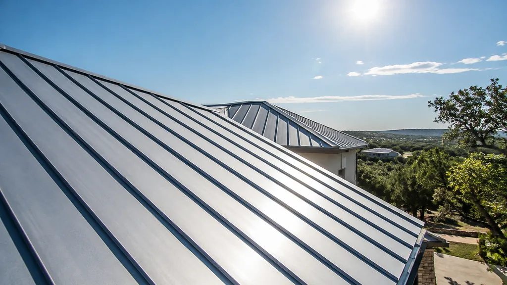 An empty roof surface: a standing-seam metal roof section glinting under strong south Texas sun