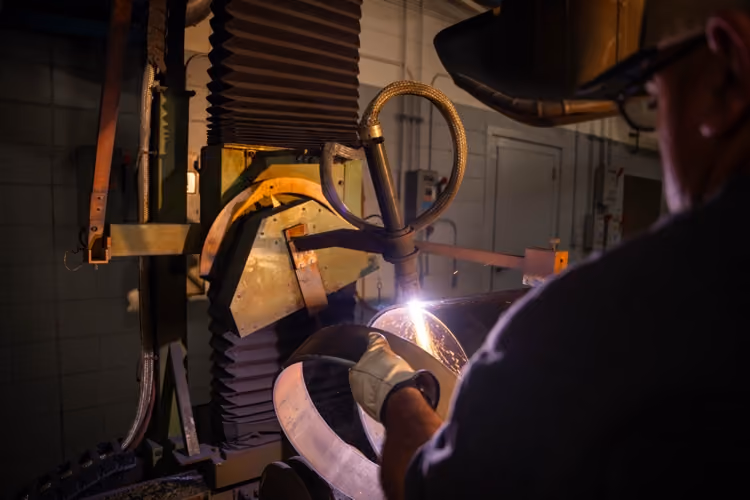 Welder joining copper pipe in the Mallory & Evans fabrication shop