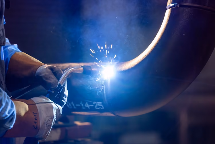 Close-up of pipe welding with sparks in the fabrication shop