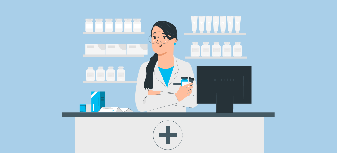 Pharmacist with glasses holding medication bottles behind a pharmacy counter with products and computer.