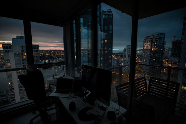 Workspace overlooking dark night sky with city lights