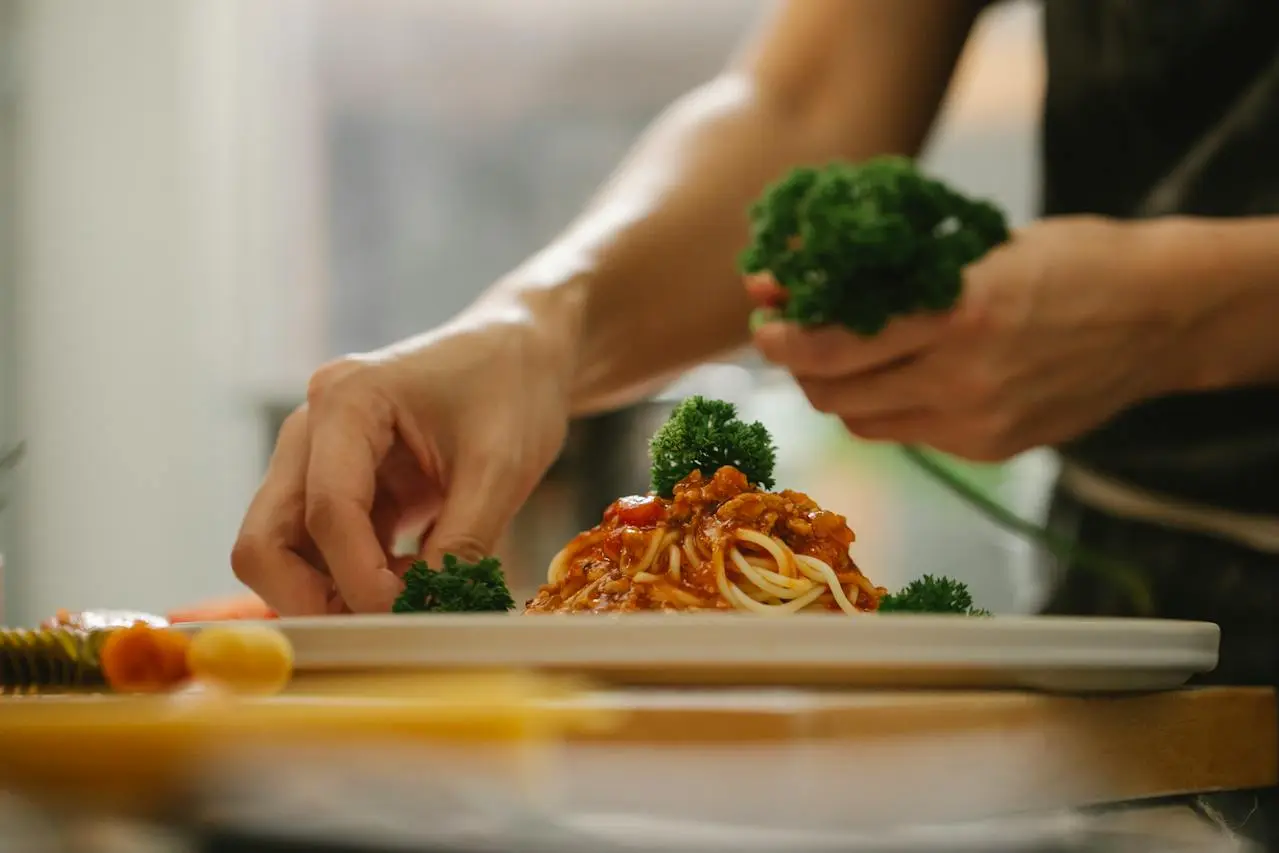 putting-brocoli-on-pasta-with-tomato-sauce