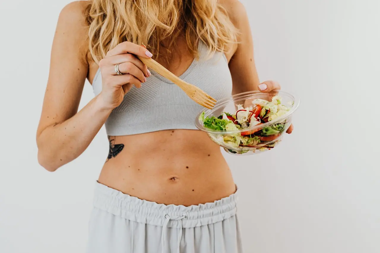 Woman eating salad with a wooden fork