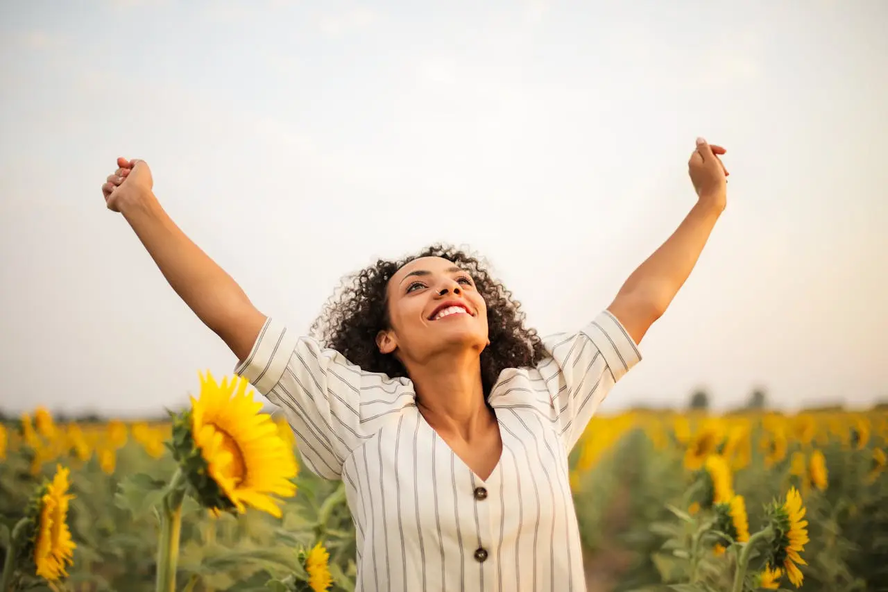 Joyful woman celebrating in a sunflower field.
