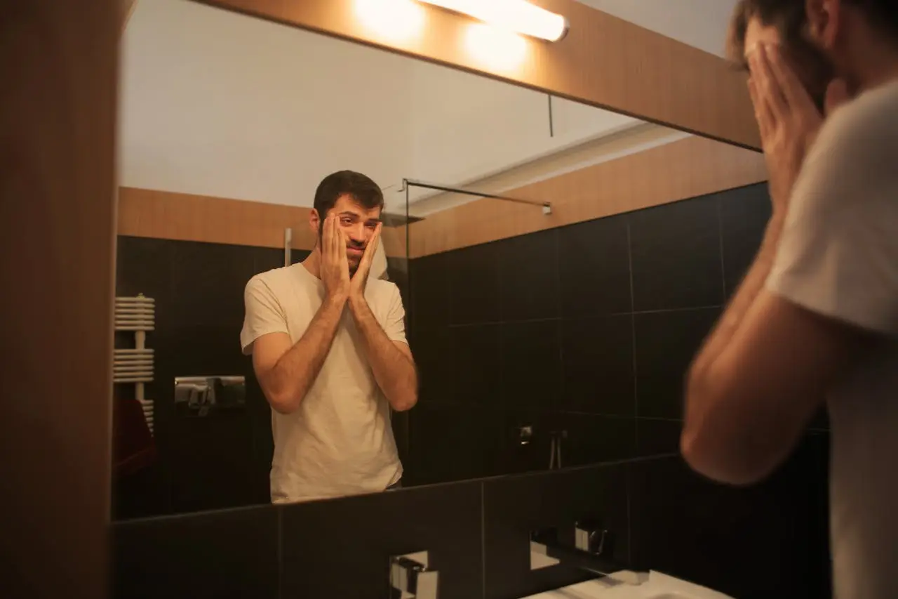 tired man looking at the mirror