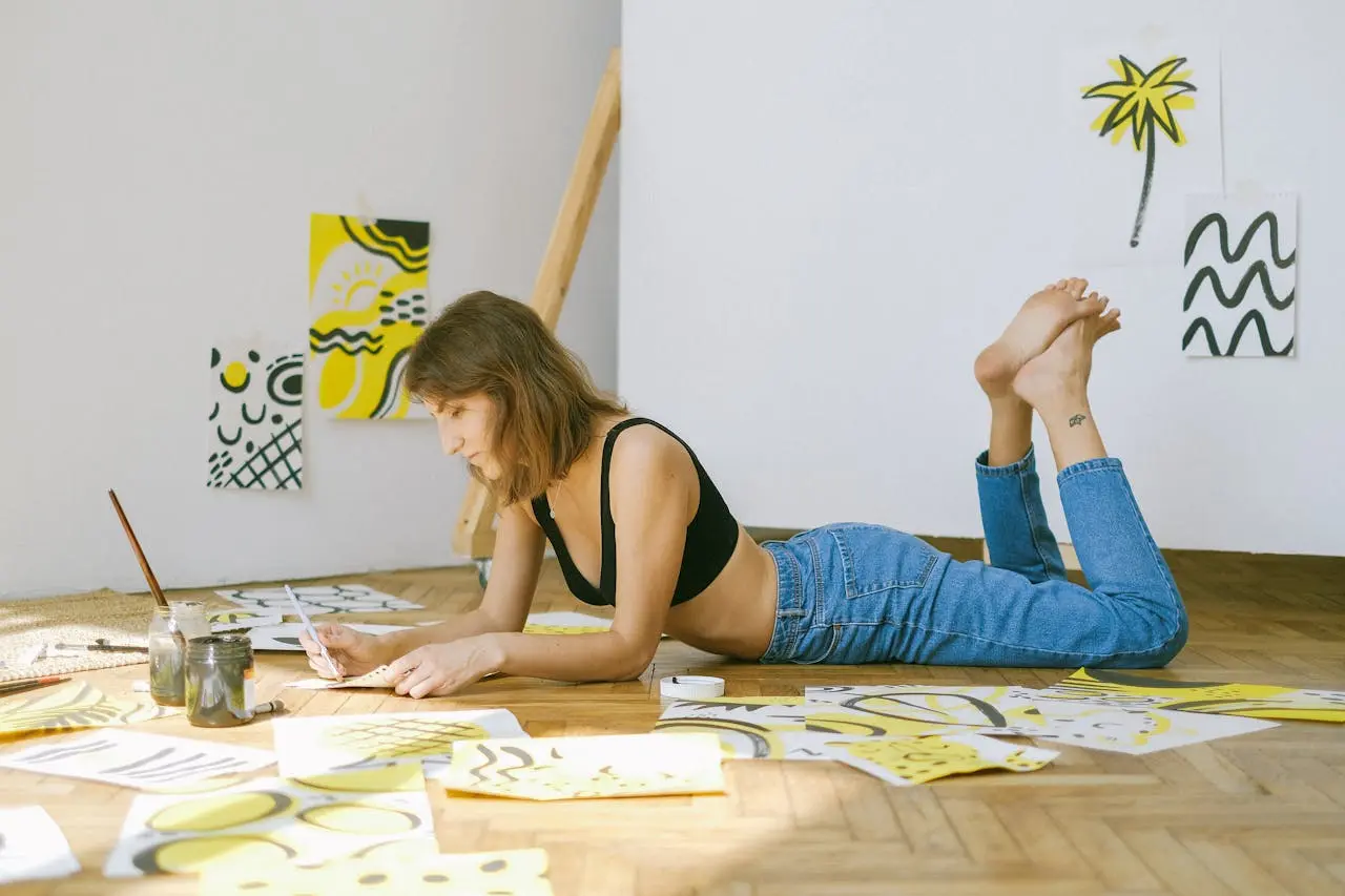woman laying on the ground drawing on pieces of paper