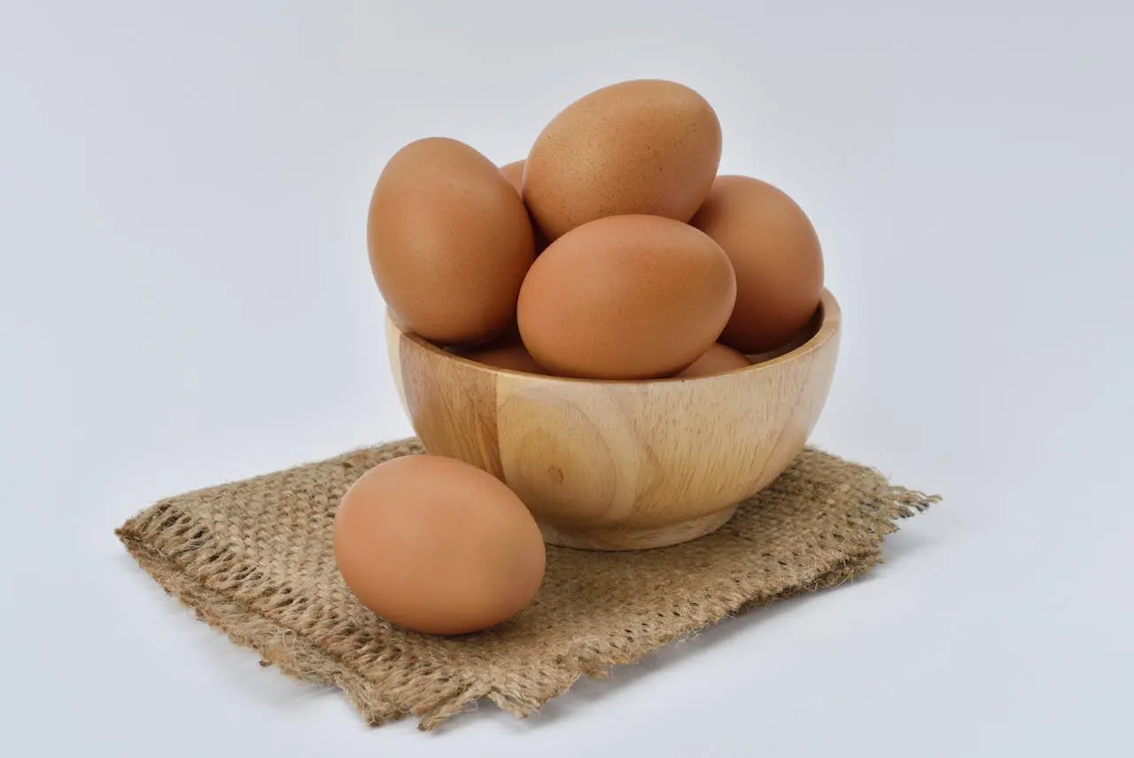 boiled eggs piled on a wooden bowl.
