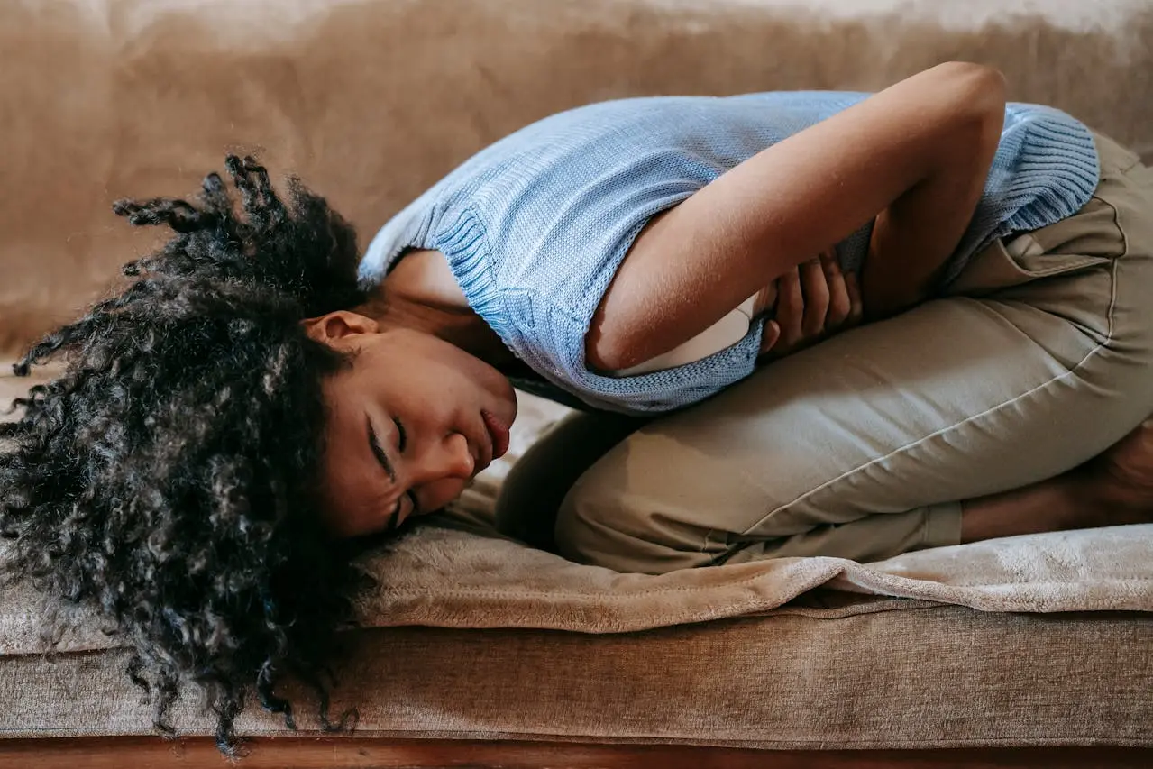 A woman curled up due to abdominal pain