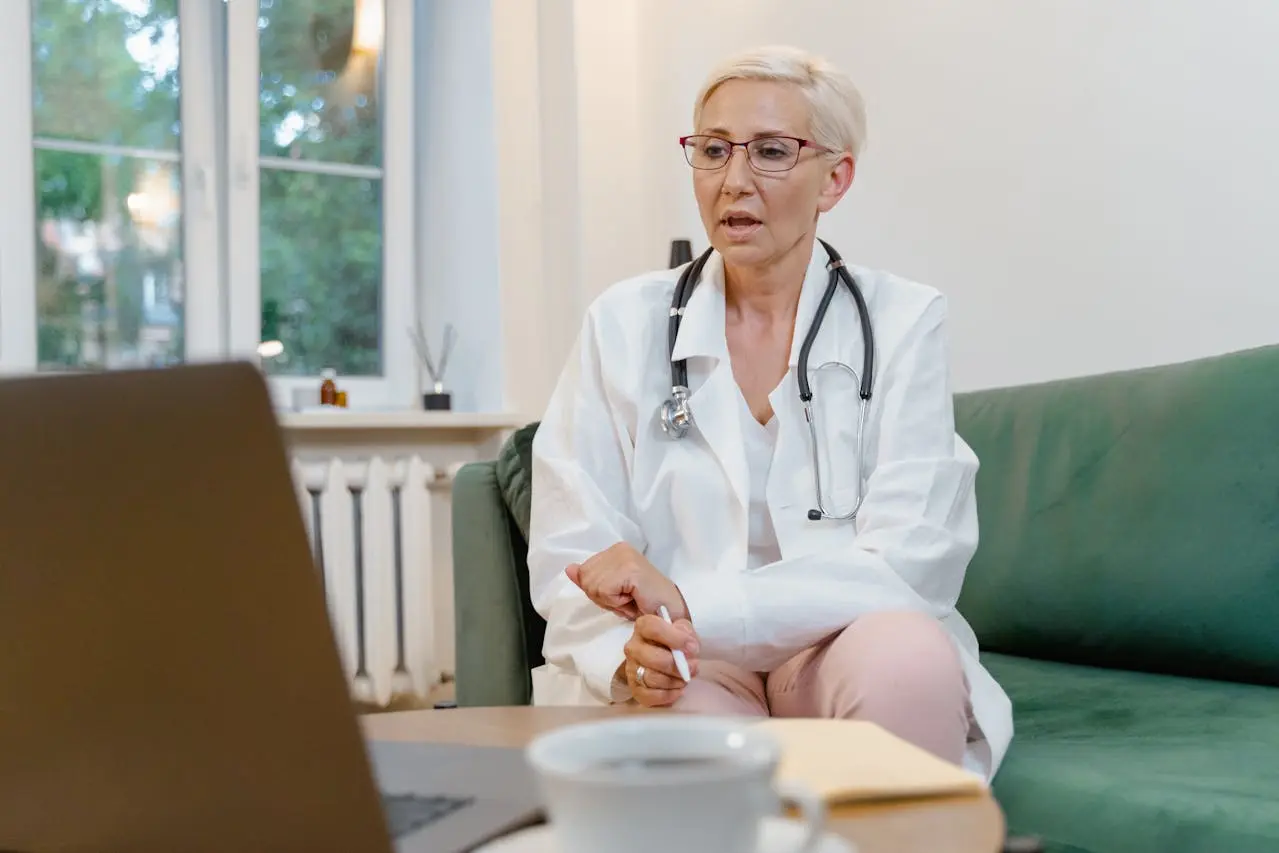 Elderly doctor talking through a laptop