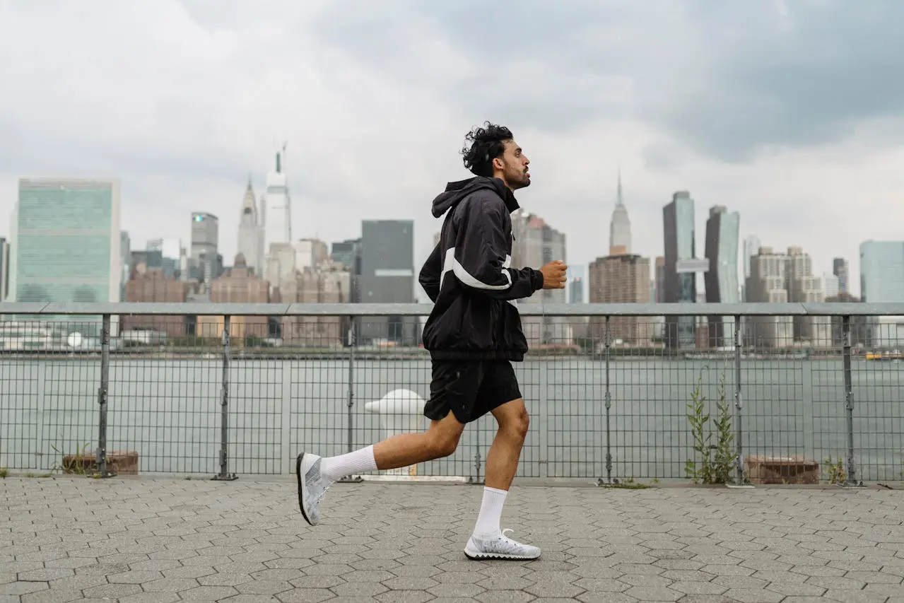 Man jogging at a bay with background buildings