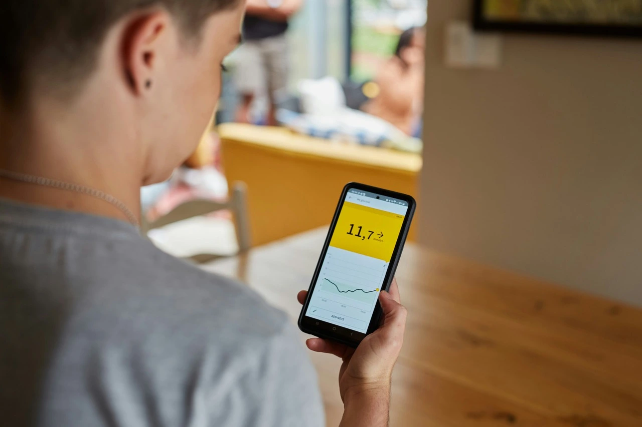 A person looks at high blood glucose results on smartphone