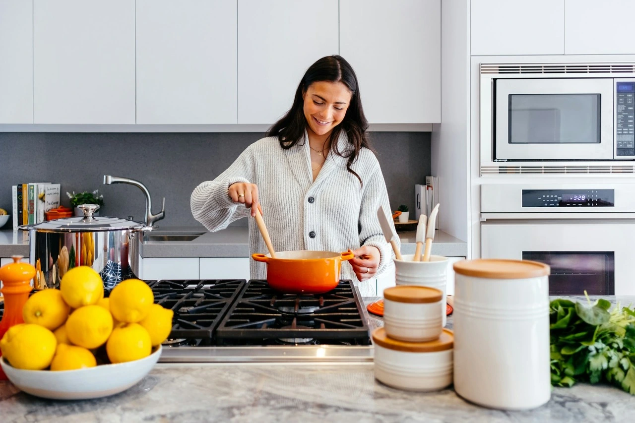 A woman happily cooking in the kitchen