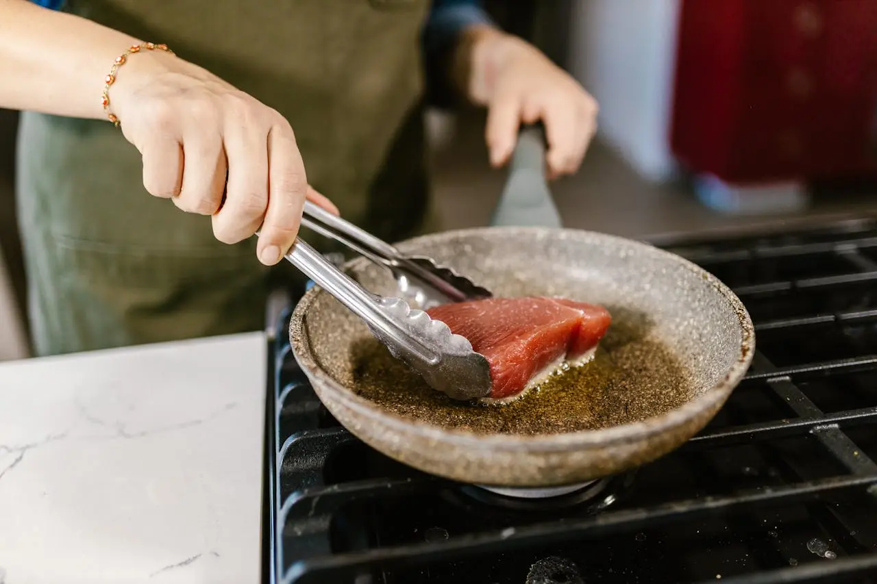 a-person-cooking-red-tuna-on-a-pan