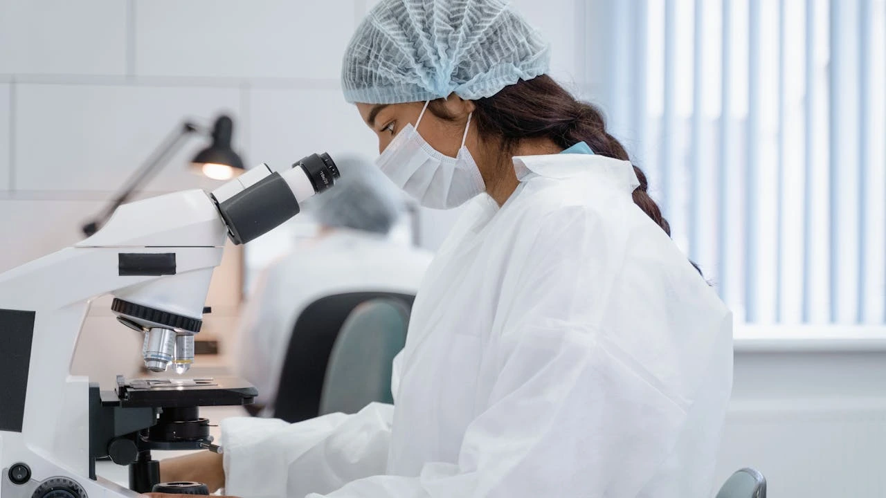 scientist looking at microscope