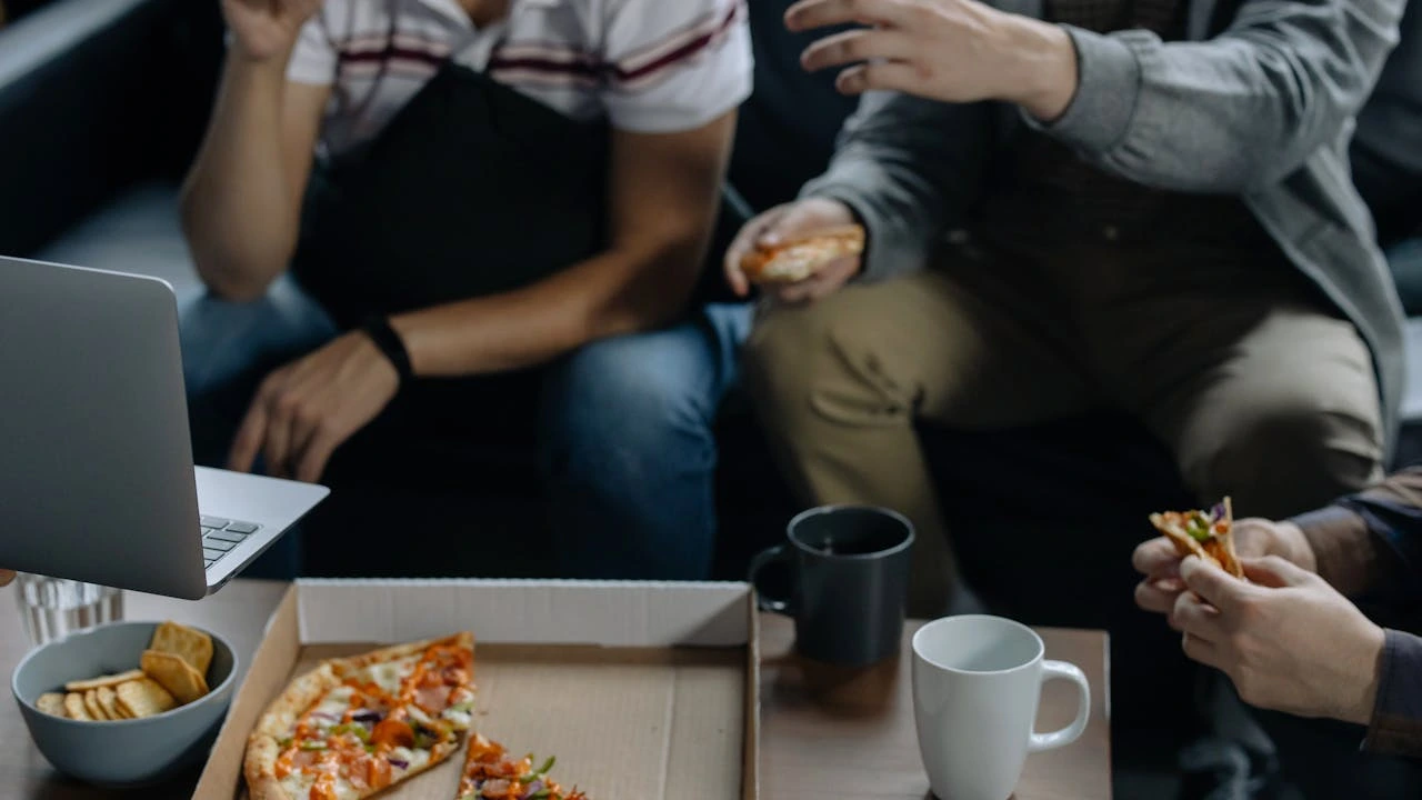 People eating while looking at a computer