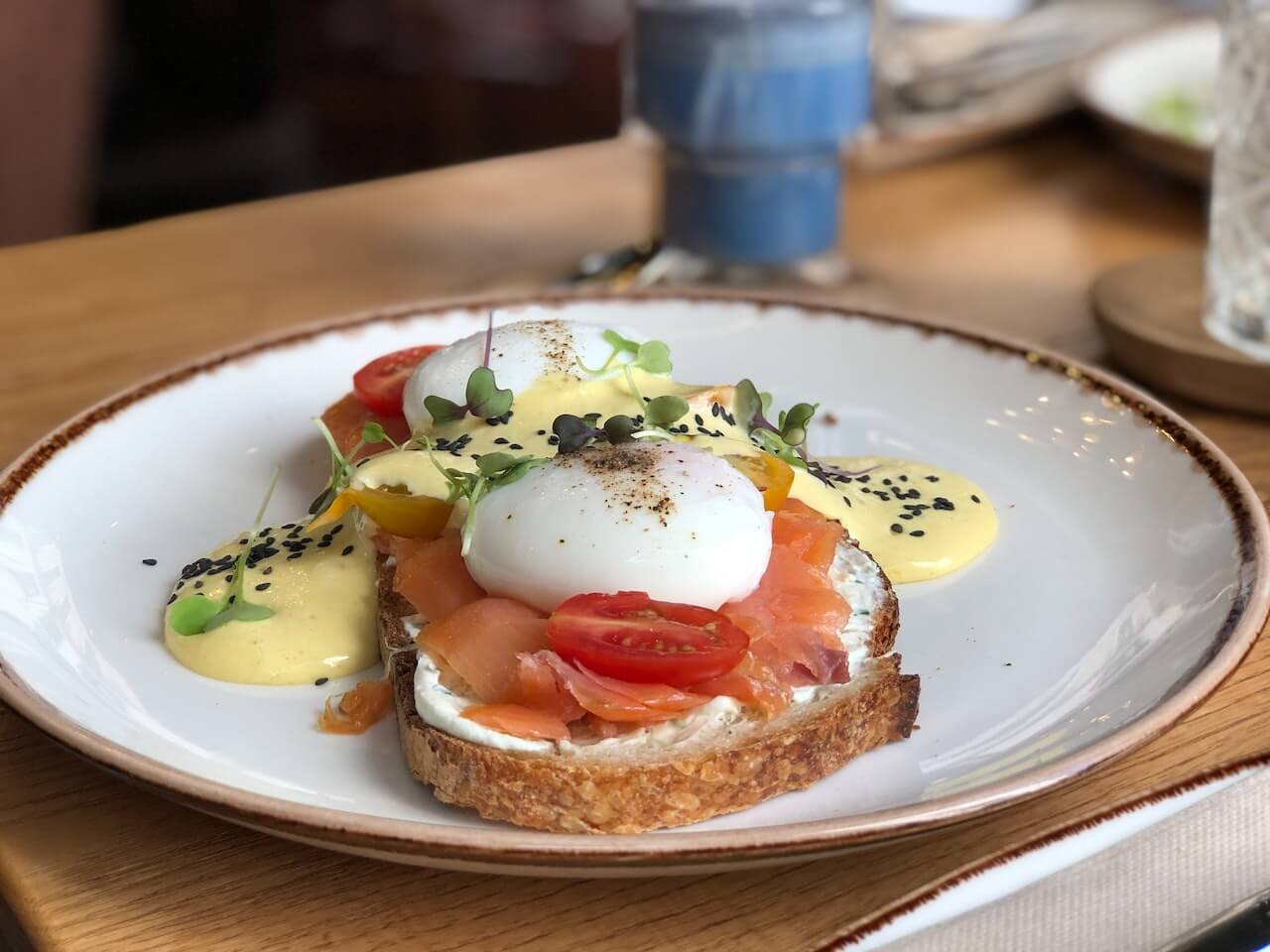 Eggs Benedict with smoked salmon, poached egg, and microgreens on toast