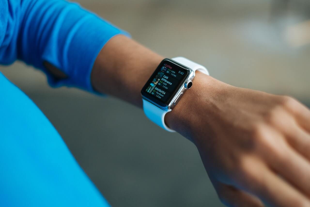 Apple Watch with fitness screen displayed on wrist wearing blue shirt