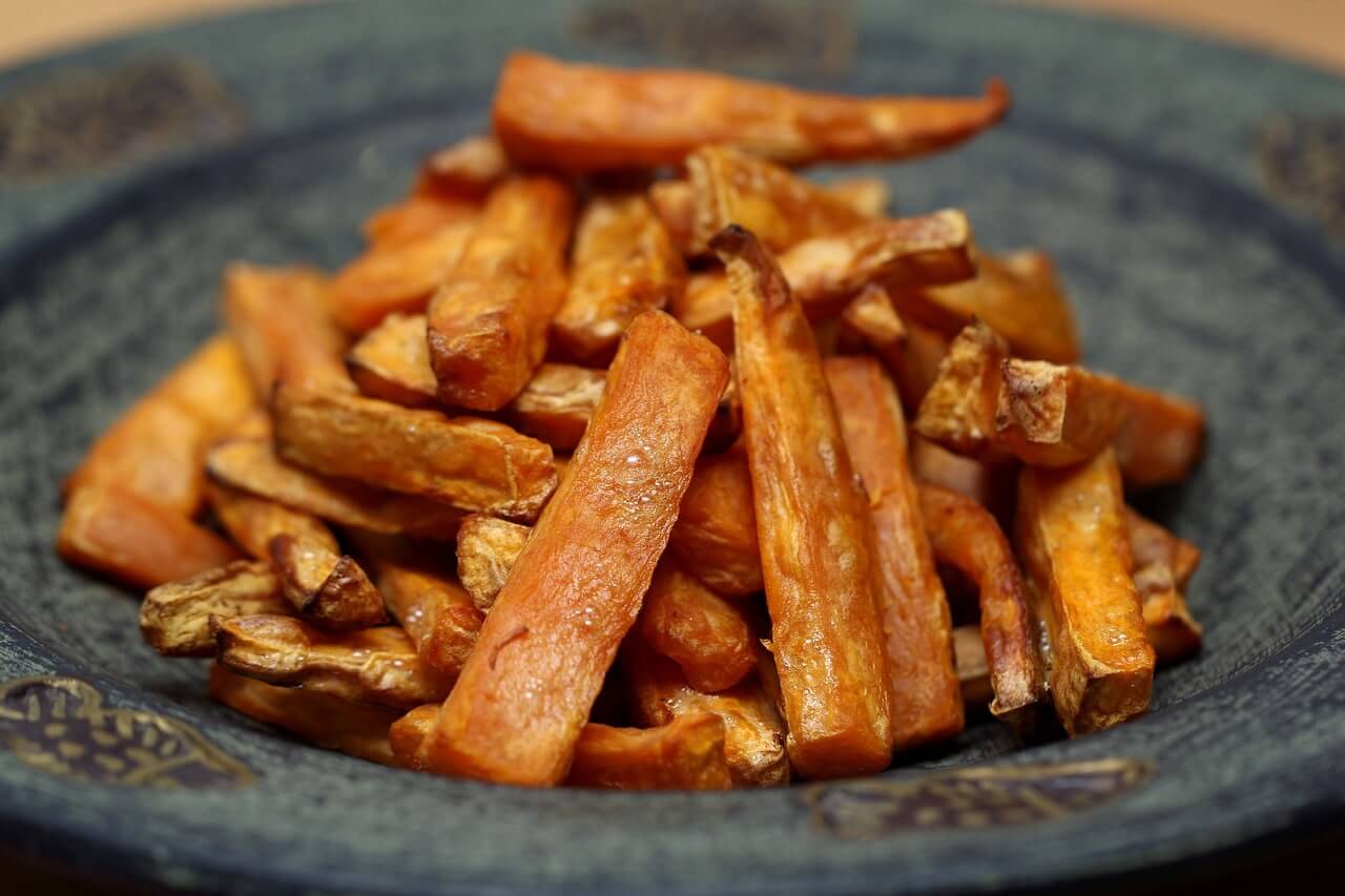 Crispy roasted sweet potato fries on a rustic blue-gray plate