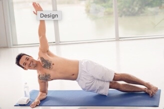 Shirtless man doing side plank exercise on blue yoga mat near window