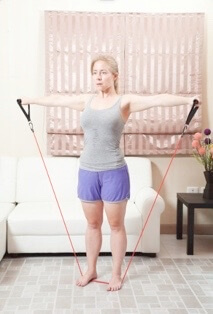 Person stretching with resistance bands in home exercise space
