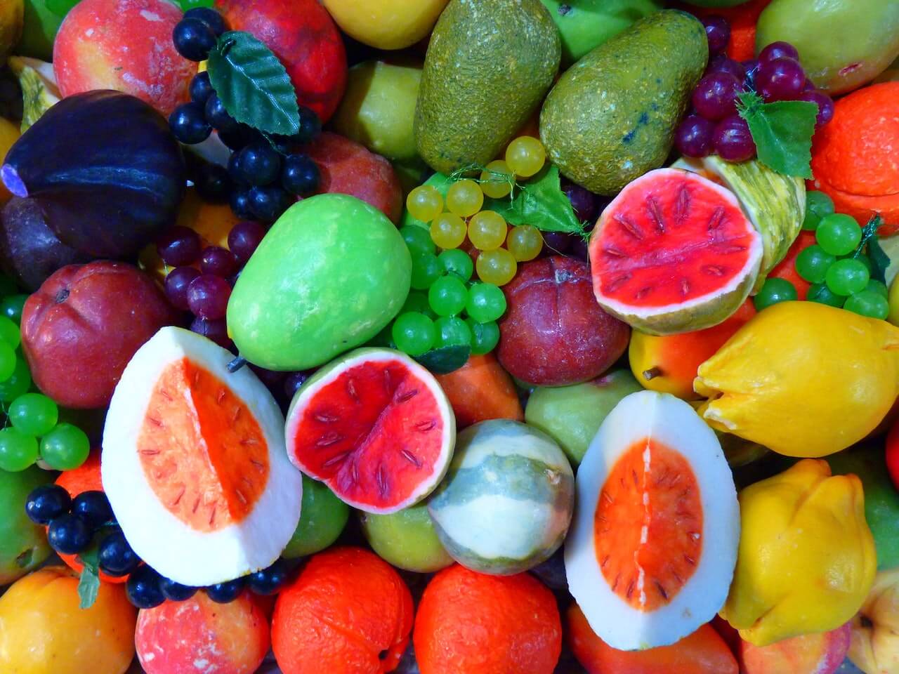Vibrant assortment of colorful fruits with cut cross-sections revealing juicy interiors