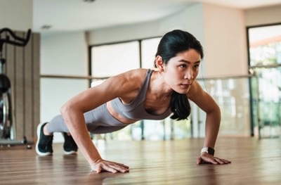 Athletic woman performing a plank exercise in a bright, modern gym studio