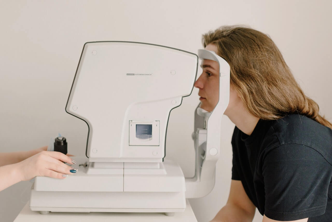 Woman undergoing eye examination with automated vision testing machine equipment