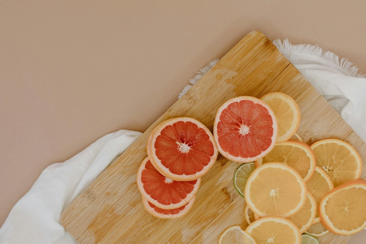 Sliced citrus fruits on wooden cutting board with white cloth