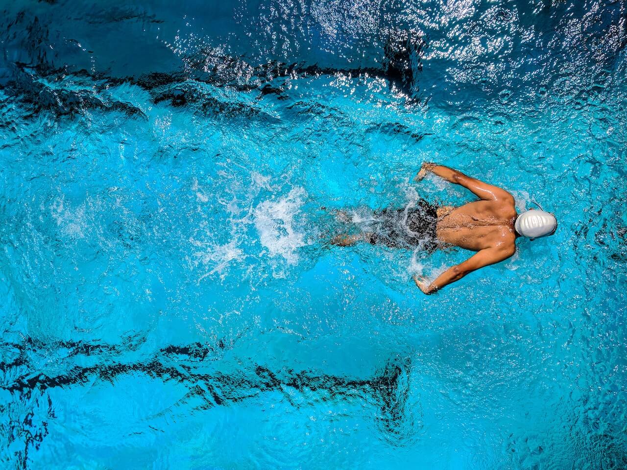 Swimmer viewed from above, gliding through vibrant blue water