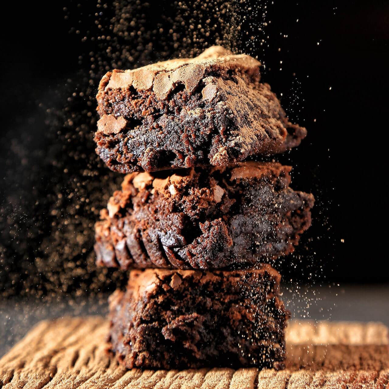 Stack of rich, crumbly chocolate brownies with cocoa dust