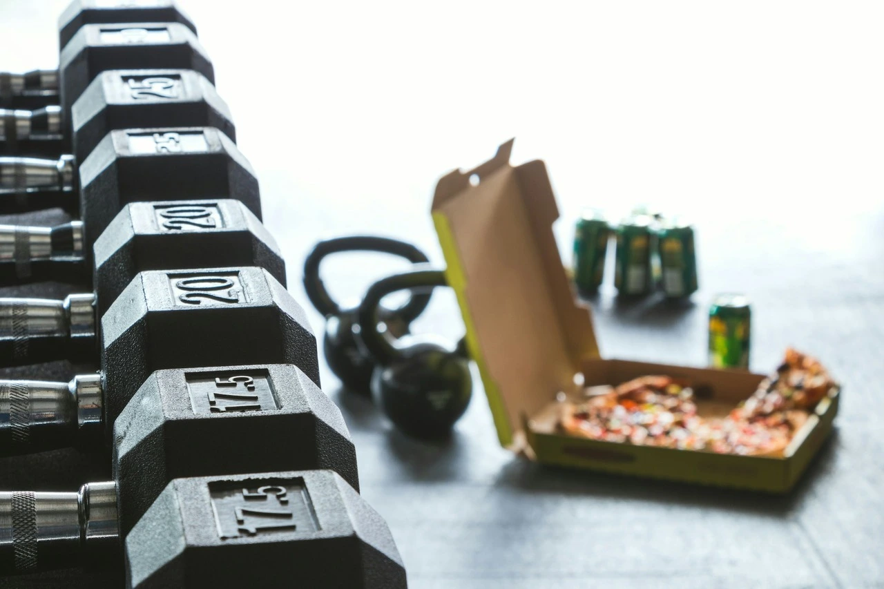 Dumbbells, kettlebell, and pizza box on a workout surface